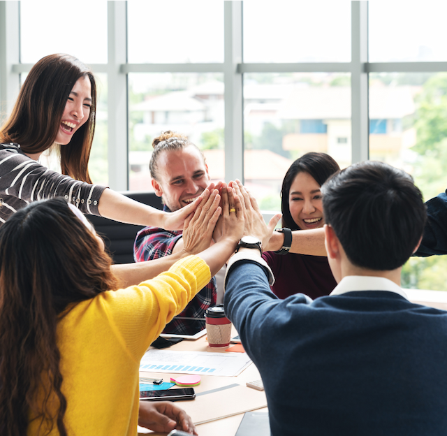 A team working together giving a group high five